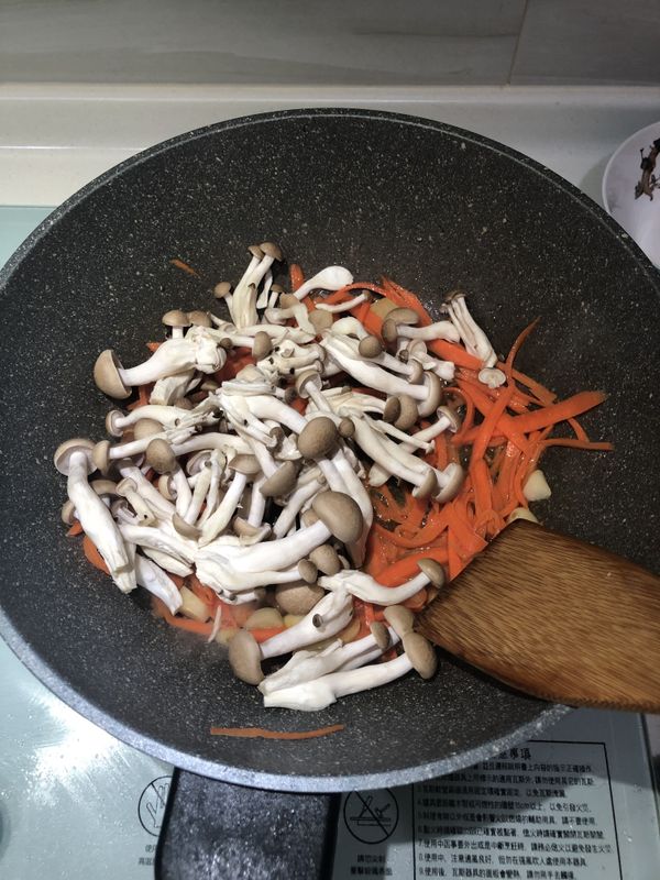 🥕紅蘿蔔絲 拌炒至微軟後，再加入 鴻禧菇 拌炒。