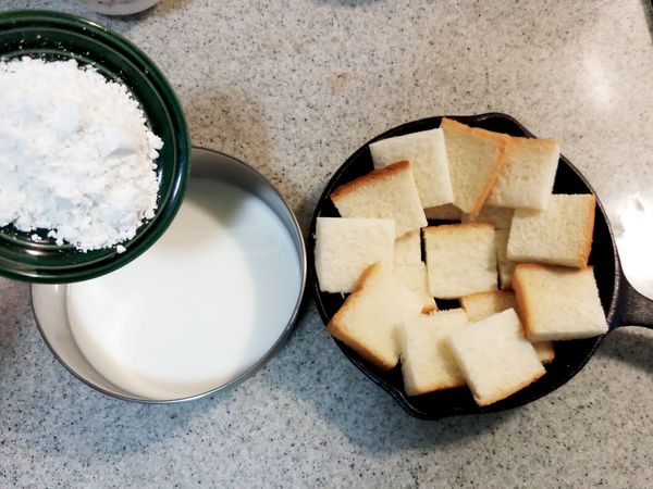 麵粉與牛奶攪拌均勻，吐司切成小塊狀放上烤盤或烤皿