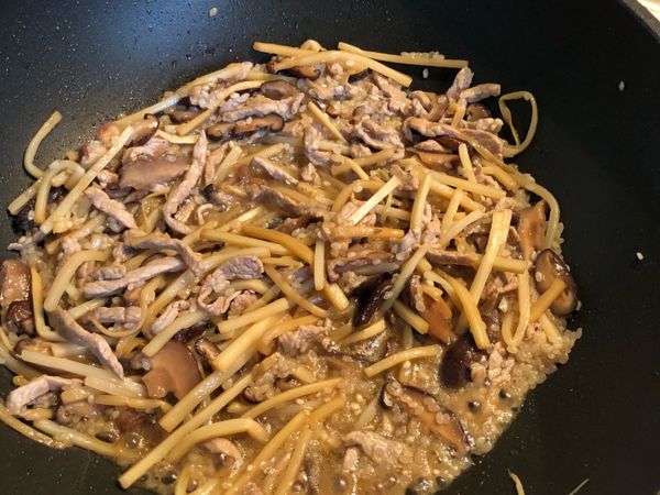 慢慢加入香菇水炒到收水再繼續加水，重覆一直到變稀飯