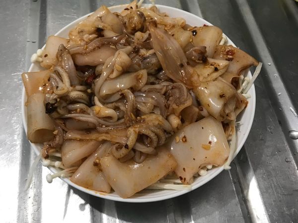 魷魚拌好後，平均放上金針菇上