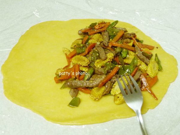 將蔬菜牛肉均勻鋪在派皮的一邊。