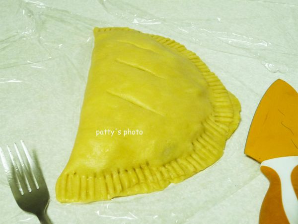 另一邊的派皮再疊上，以叉子按壓四周使其密合，表面則以刀畫上三痕，讓烘烤時產生的熱氣有處可跑。