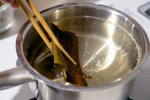 將昆布水放到爐上加熱，當水開始滾沸後取出昆布