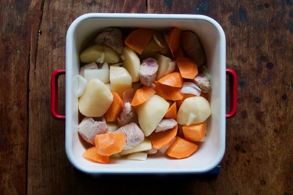 投入馬鈴薯與紅蘿蔔拌炒讓蔬菜皆裹上炒菜油。