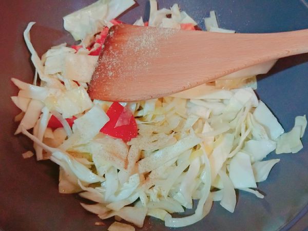 洋蔥炒好後，放入高麗菜絲與番茄，翻炒。之後加入胡椒鹽。炒好後先用盤子盛起。
