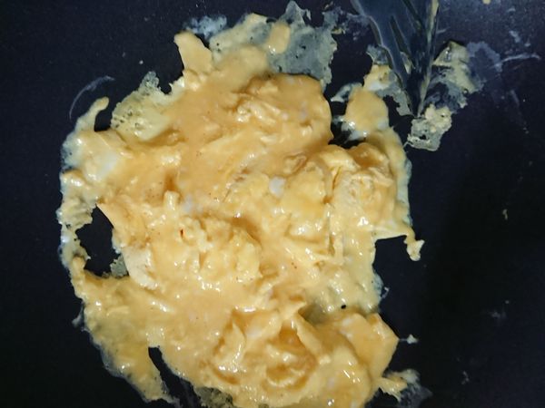 呈半熟凝固狀態加入醬油繼續拌炒