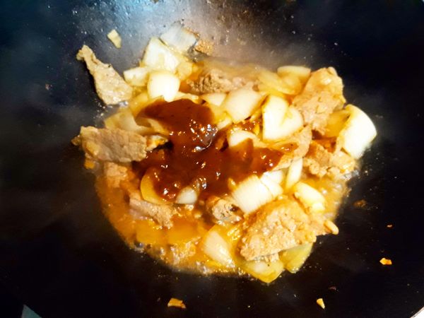 加進洋蔥塊和蘑菇醬微炒後，再加進半杯水，蓋上蓋子悶2分鐘
