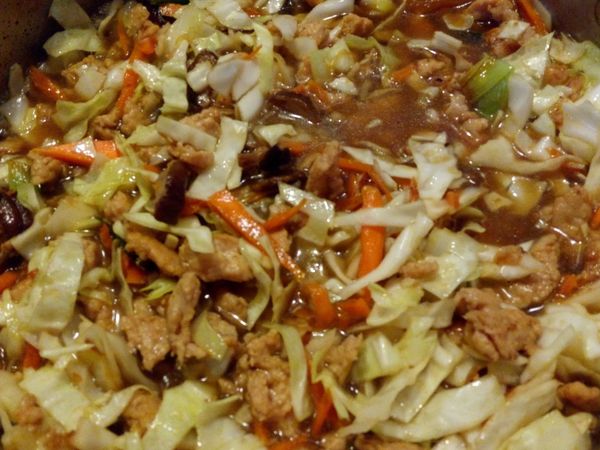 加入高麗菜拌炒，加入高湯，水以及剛才爆香過的香菇。嘗一下湯汁味道，需比平常喝的湯更鹹一點，不夠鹹可再加醬油。