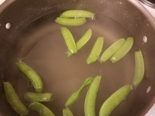 將麵撈出之後，把去掉頭尾的荷蘭豆放入煮一分鐘。