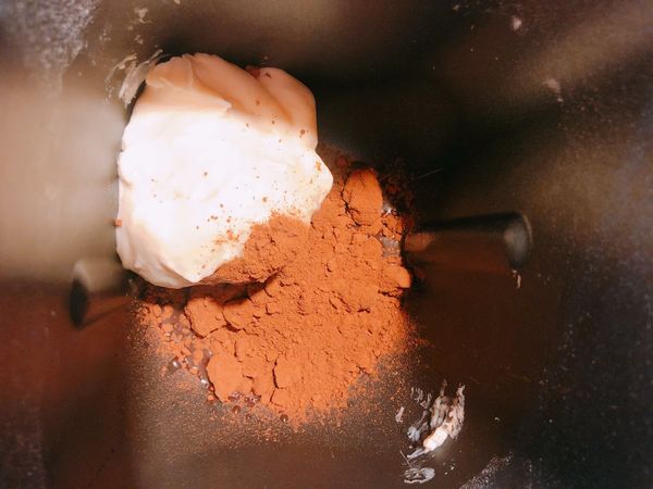 將另一份麵團，再次投入麵包機中，加入可可粉及水後，啟動麵包機烏龍麵模式，這次不需要行程跑完，只要麵團與可可粉完全融合、成團就可以了