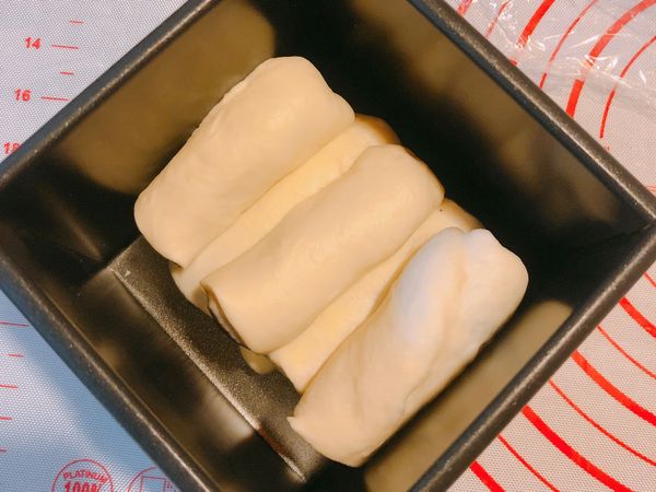 將四個做好的麵團對切，（在做整形時，麵團的長度約要模型長度的2倍）再依序放入模型中，進行第二次發酵，約50分鐘