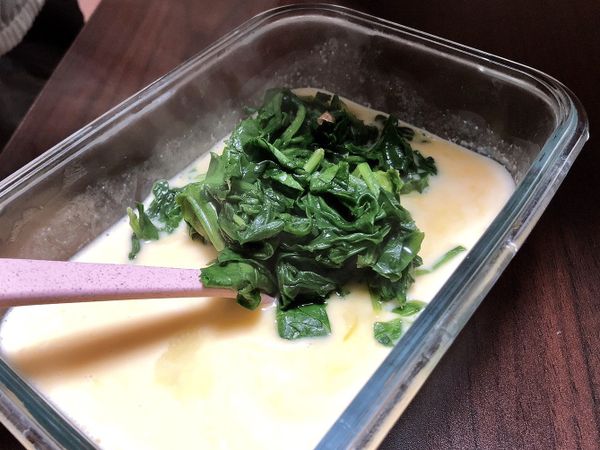 接著將炒好的料全部倒入蛋液中，記得不要把菠菜水一起倒進去。