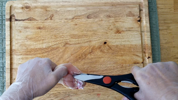 用剪刀把雞腿肉與骨頭分離,用左手將雞腿肉往下推,使用尾巴銳利的刀將骨頭切掉,把雞肉翻面. 去骨完成.