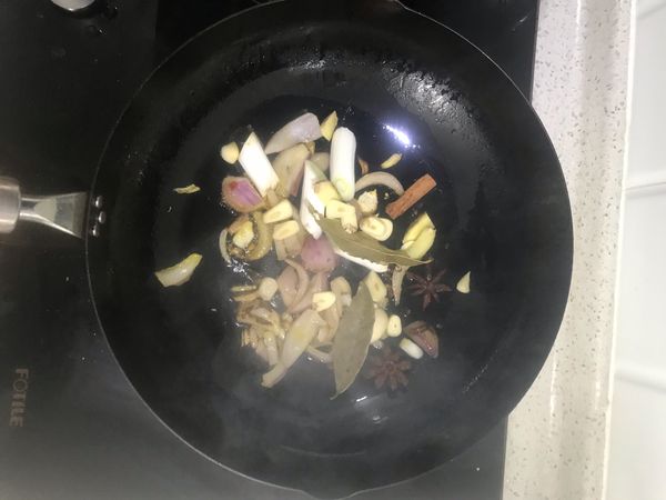 洋葱微黄后，放入除冰糖外的其它调料炒香，再喷入酱油，稍稍煮会。
