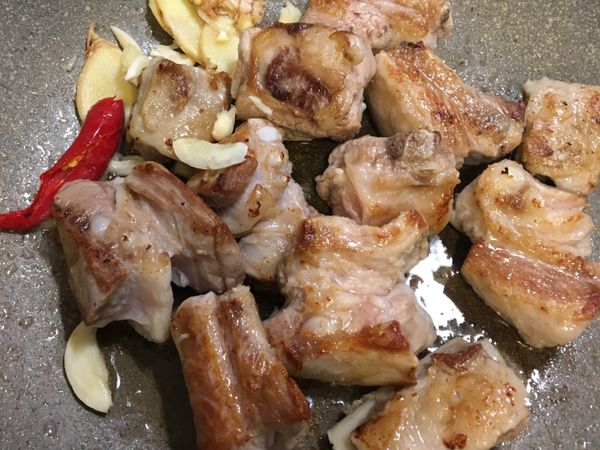 將子排煎到金黃色後加入蒜末、薑片、辣椒，炒出蒜香味⋯