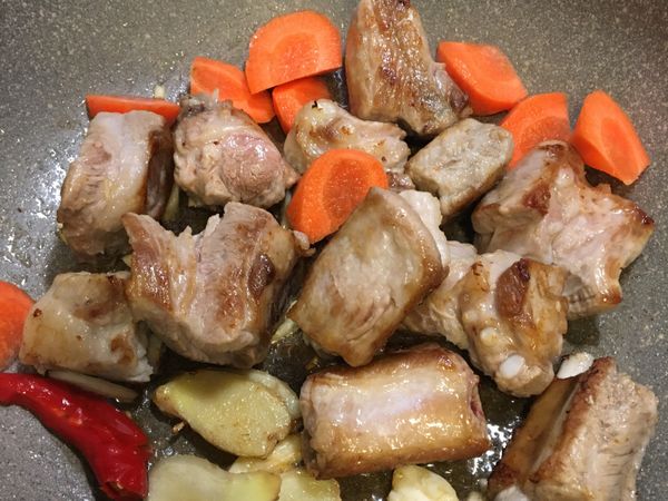 加入紅蘿蔔塊翻炒，使之均勻裹上油⋯