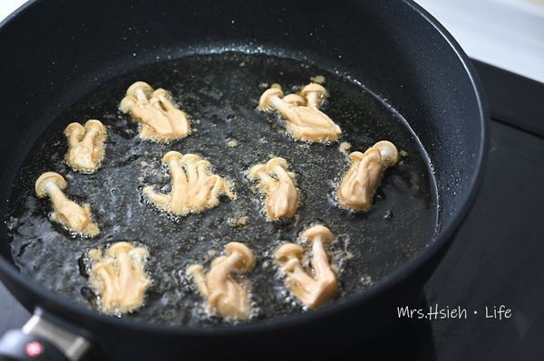 將步驟3的美白菇依序下鍋，約煎1分鐘翻面，兩面都煎至金黃色即可起鍋瀝油