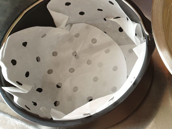 把烘焙紙揉一揉後舖在模具上（圖片因沒有一般烘焙紙，所以已有洞烘焙紙交疊代替!建議還是要用一般烘焙紙，烤起來比較漂亮哦！）