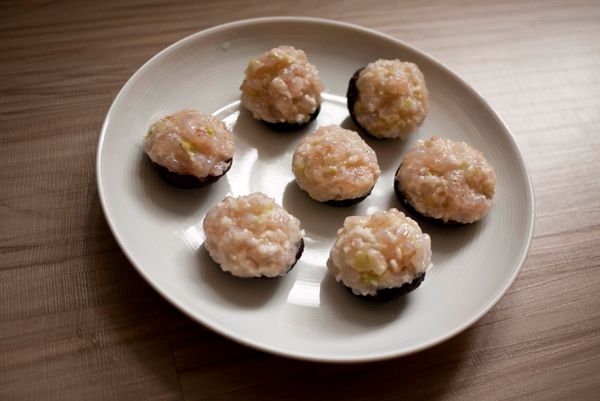 香菇灑上些玉米粉,將蝦泥餡填滿香菇中