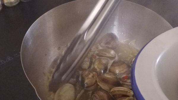 取出以清洗好的蛤蜊放入平底鍋稍微翻炒後蓋上鍋蓋，煮到蛤蜊開口即可取出備用，取出後可先用黑胡椒做調味