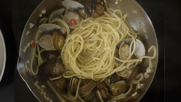 後隨即放入剛剛取出的蛤蜊、撤上些許羅勒葉在一起攪拌後即可成盤