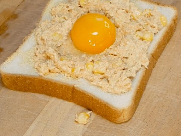 將咖哩醬塗在吐司上，中間用湯匙輕輕的壓出一個凹槽，最後放入蛋黃。