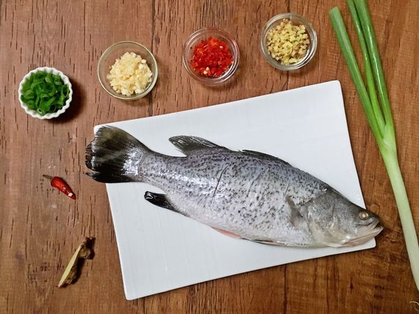 將鱸魚二面劃刀，以醃料略醃10分鐘，再以廚房紙巾拭乾水份。