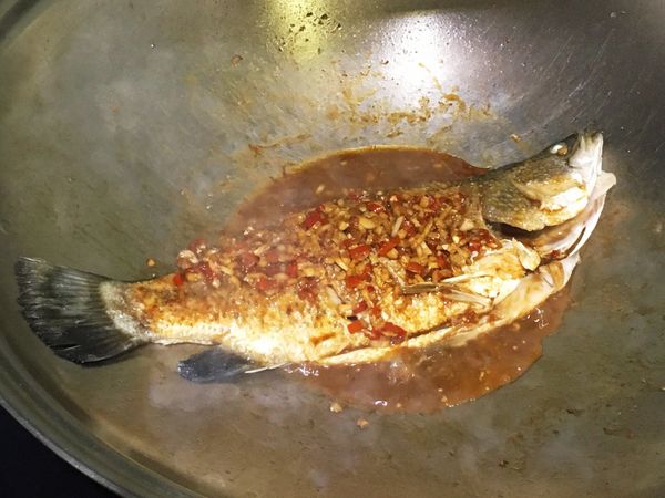 原鍋爆香蒜末、薑末及辣椒末，將魚放入煮至入味，起鍋前撒上蔥花即可。