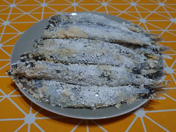 將裹有蛋液的柳葉魚均勻沾上木薯粉，並放置十分鐘