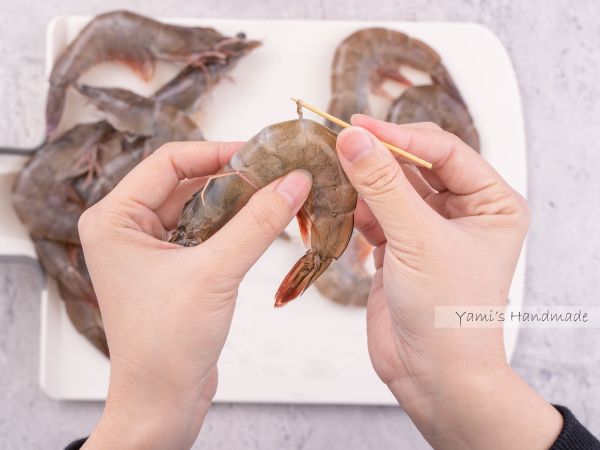 用牙籤從殼的第三個節處插入，挑出腸泥