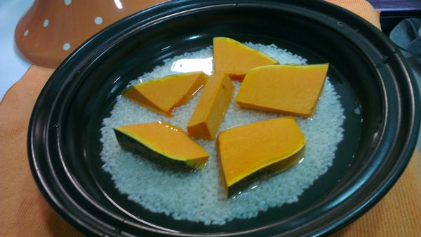 米洗好，倒到塔吉鍋裡，南瓜一起進去煮，因為有南瓜的關係，所以水量是比煮飯的水再多半杯，小火約15分鐘(煮到水差不多被米和南瓜吸乾)