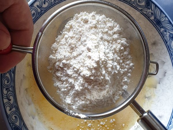 先將蛋黃，砂糖，沙拉油和鮮奶攪拌均勻，再加入過篩的低筋麵粉後，輕輕拌勻即完成蛋黃糊