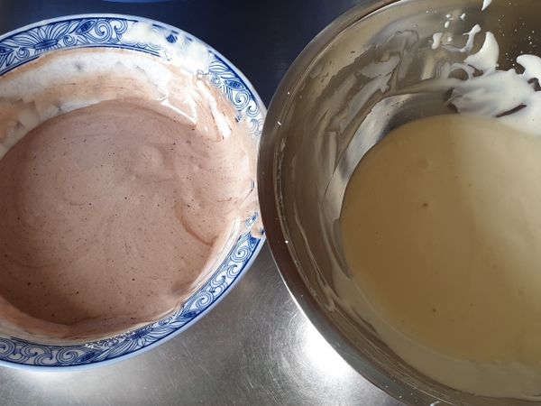 將蛋白霜以刮刀挖1/3-1/2至蛋黃糊中，切拌均勻，再將其倒回蛋白霜中切拌均勻!
將麵糊分兩份，其中一份加入可可粉（約2-3g）後輕輕拌勻