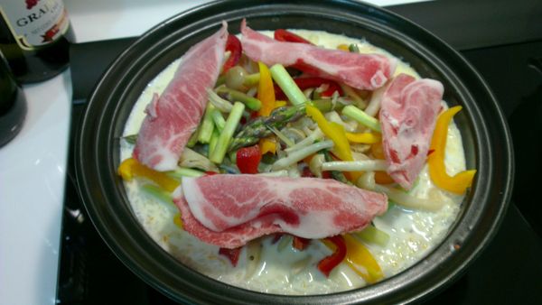 倒入鮮奶，順便攪碎南瓜，讓南瓜融入鮮奶裡，加入適量的鹽，接著把蘆筍、甜椒、鴻禧菇和豬肉片舖在最上面，蓋上鍋蓋繼續煮10分鐘