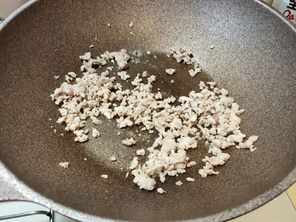 冷凍絞肉不必加油，直接丟進去，炒散。