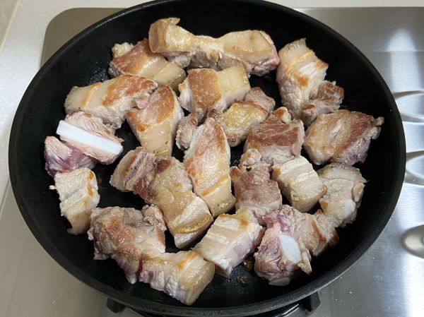 將五花肉切塊，乾煎至兩面焦黃。