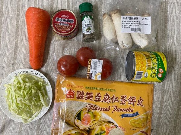 首先備齊番茄、高麗菜絲、紅蘿蔔、蛋餅皮一張、黑胡椒、廣達香肉醬、永偉玉米粒