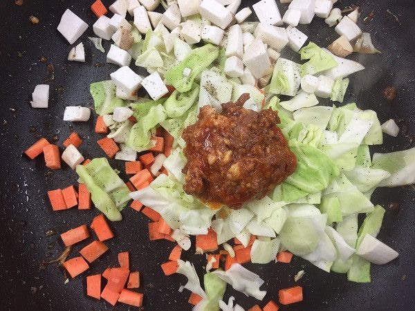 將紅蘿蔔刨成條狀
杏鮑菇、番茄切丁
並放入鍋中再放入高麗菜絲、廣達香肉辣醬