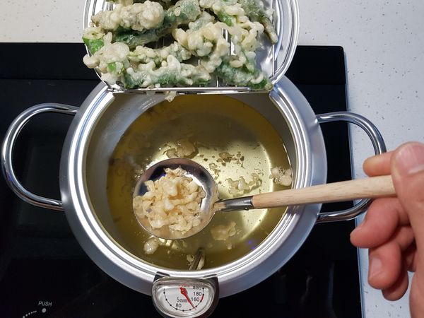糯米椒炸1分鐘後撈起，瀝乾多餘的油。

油鍋中的炸過麵衣也要撈起，不要丟掉，同樣瀝乾油，備用。