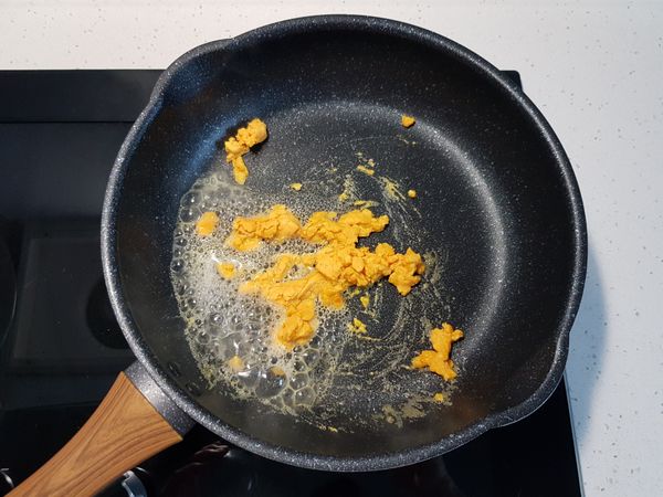 加入鹹蛋黃泥拌炒，再加入米酒，嗆出鹹蛋香氣。

不停的拌炒至鹹蛋黃起泡。
