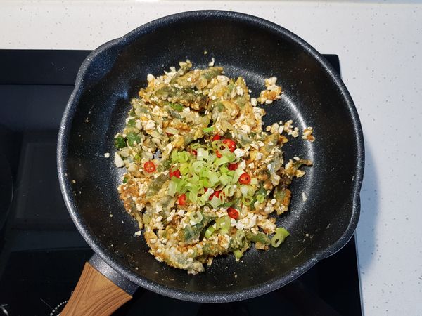 隨後加入蔥花、辣椒、白胡椒粉，翻炒均勻後即可關火。