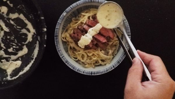 將煎好的牛排斜切成片，鋪在麵上淋上些許白醬、撒上黑胡椒、羅勒葉即可