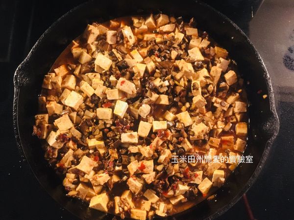 放入炒過的蘑菇，豆腐，豆瓣醬，醬油，鹽和水。煮至沸騰，再加入太白粉水（也可以不勾芡），再次煮滾，關火再加入蔥花。