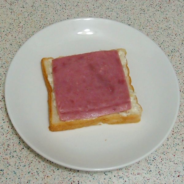 將白醬塗抹於吐司上，舖上火腿，再抹一些白醬，蓋上第二片吐司，抹白醬後舖上乳酪，中間要留一個洞。以180度烤15分鐘左右，取出後放上一顆生蛋黃即可。