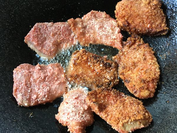 熱鍋熱油時放入沾好地瓜粉的紅麴松阪豬，中小火炸熟⋯
因有加醬油膏的關係，火不要開太大，不然容易炸黑。
*不想用太多油，所以用半煎炸的方式。
*入鍋後不要急著翻面，讓一面肉煎熟再翻面煎，地瓜粉才不會散掉。