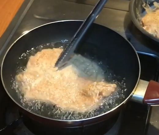 放入筷子測量油溫，筷子四周起泡時，將火轉小，加入豬排，不需急著翻動