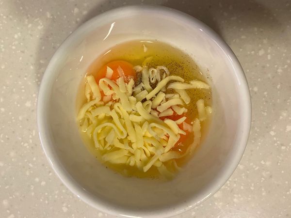 將蛋、起司絲、胡椒粉、玫瑰鹽全加入碗中。早上要加快速度！直接加90度熱水約20ml，完全混勻！若較有時間也可以把水換成鮮奶，需要攪拌較久的時間。