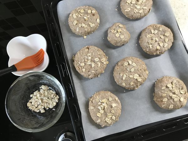 放在鋪好烘焙紙的烤盤上，表面刷上牛奶（蛋液或融化的奶油亦可），灑點燕麥片裝飾一下