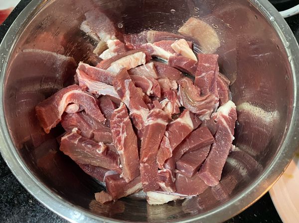 牛肉逆紋切成條狀（約手指的粗度）有點肥的牛肉特別好吃，加入所有醃料，用手拌勻讓牛肉吸收醃料