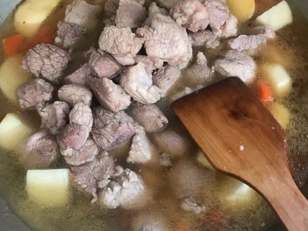 把炒好的紅蘿蔔及馬鈴薯及梅花肉，加水淹沒，中火慢慢煮，要隨時搗伴，以防底部焦黑。